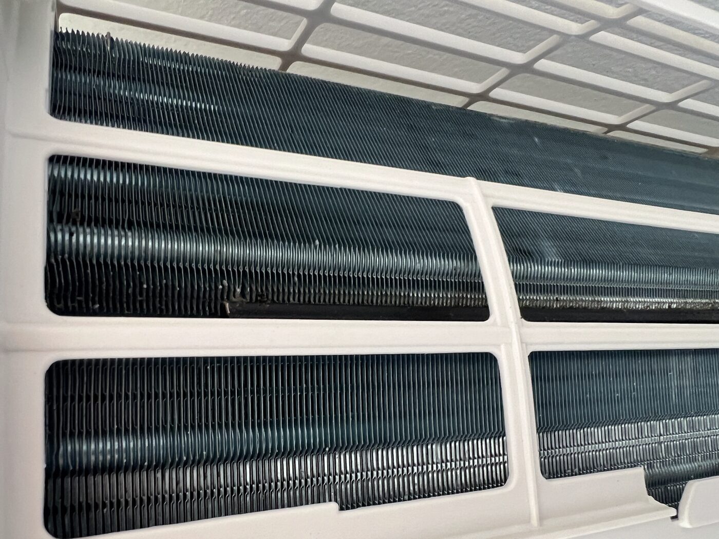 Close-up of clean AC evaporator coils after servicing, fins clear with full heat transfer surface exposed.