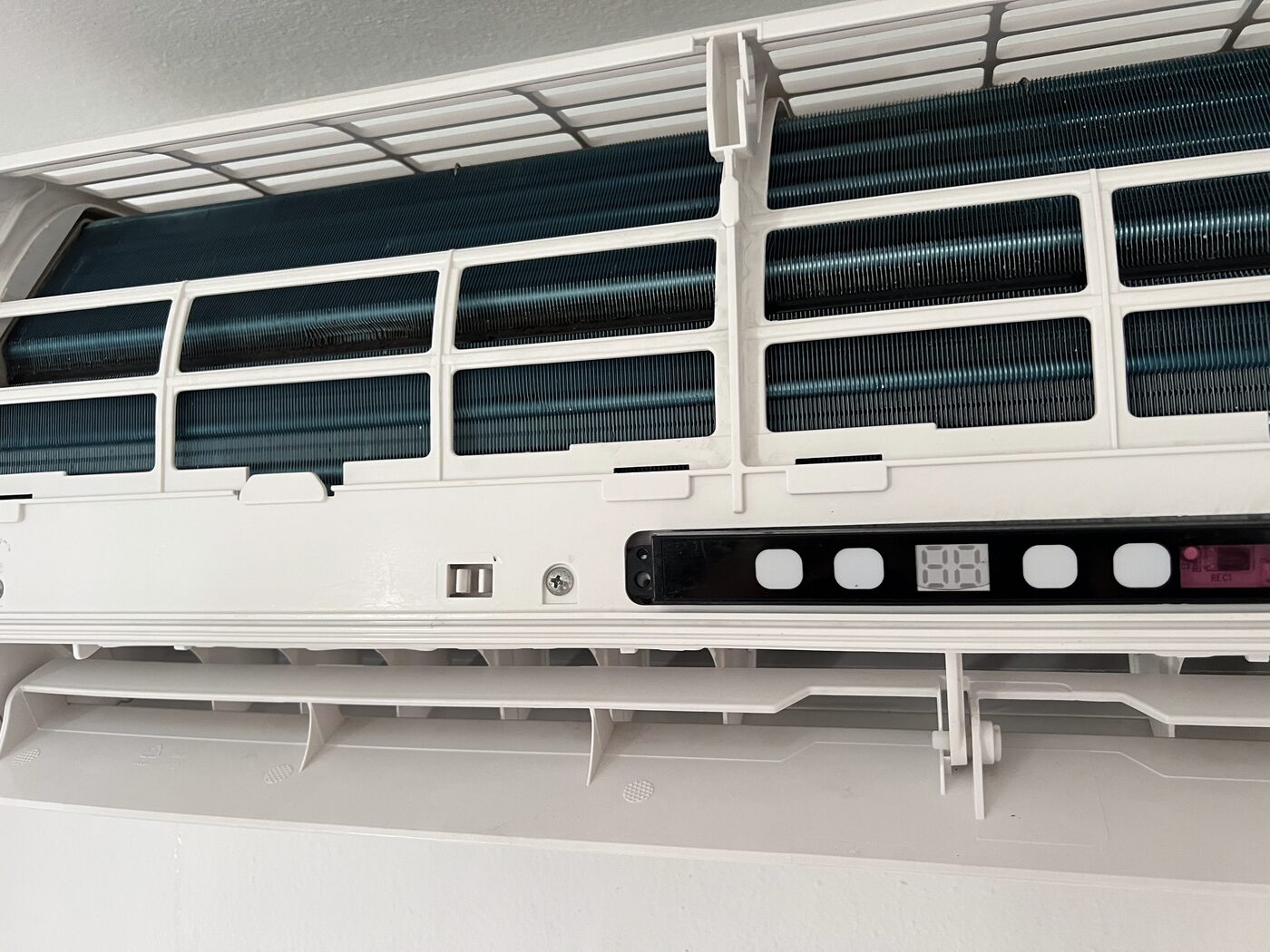 AC unit interior after professional deep clean, showing restored clean blue-green evaporator coils and clear fascia.